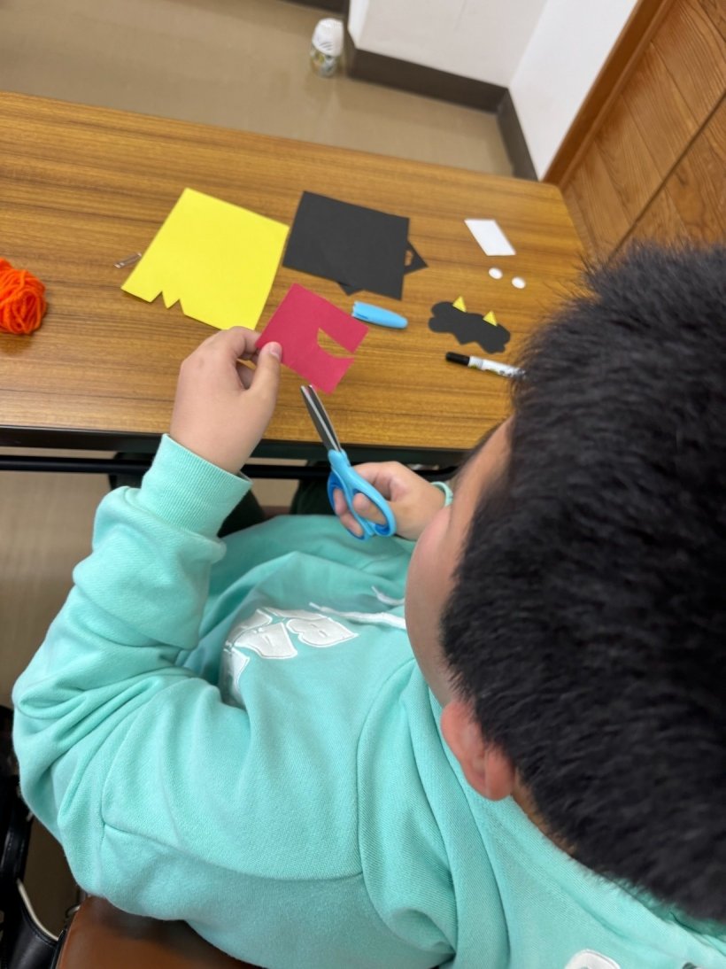 赤い画用紙を切っている